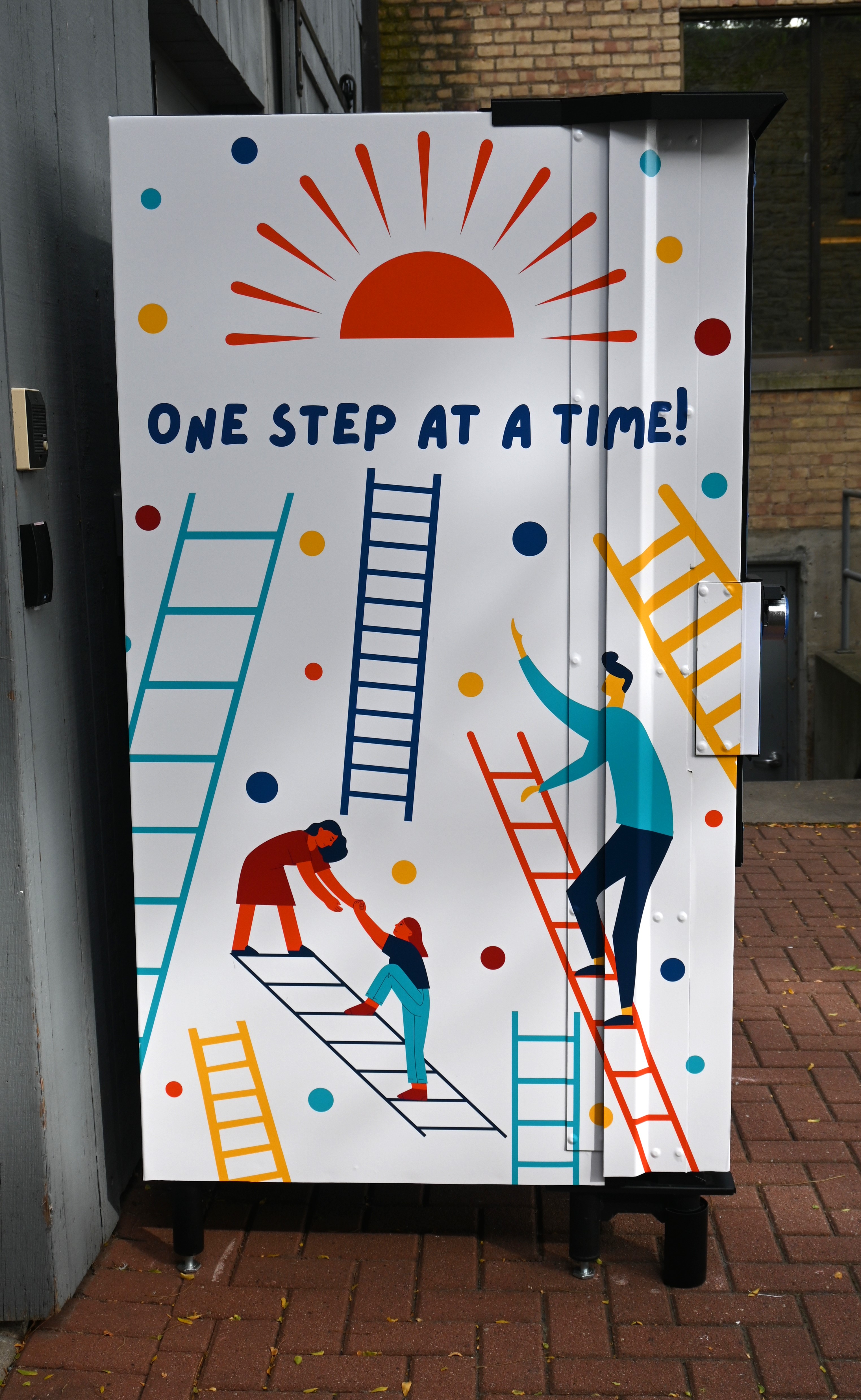 photo of left side of the vending machine with ladders and people climbing towards the sun