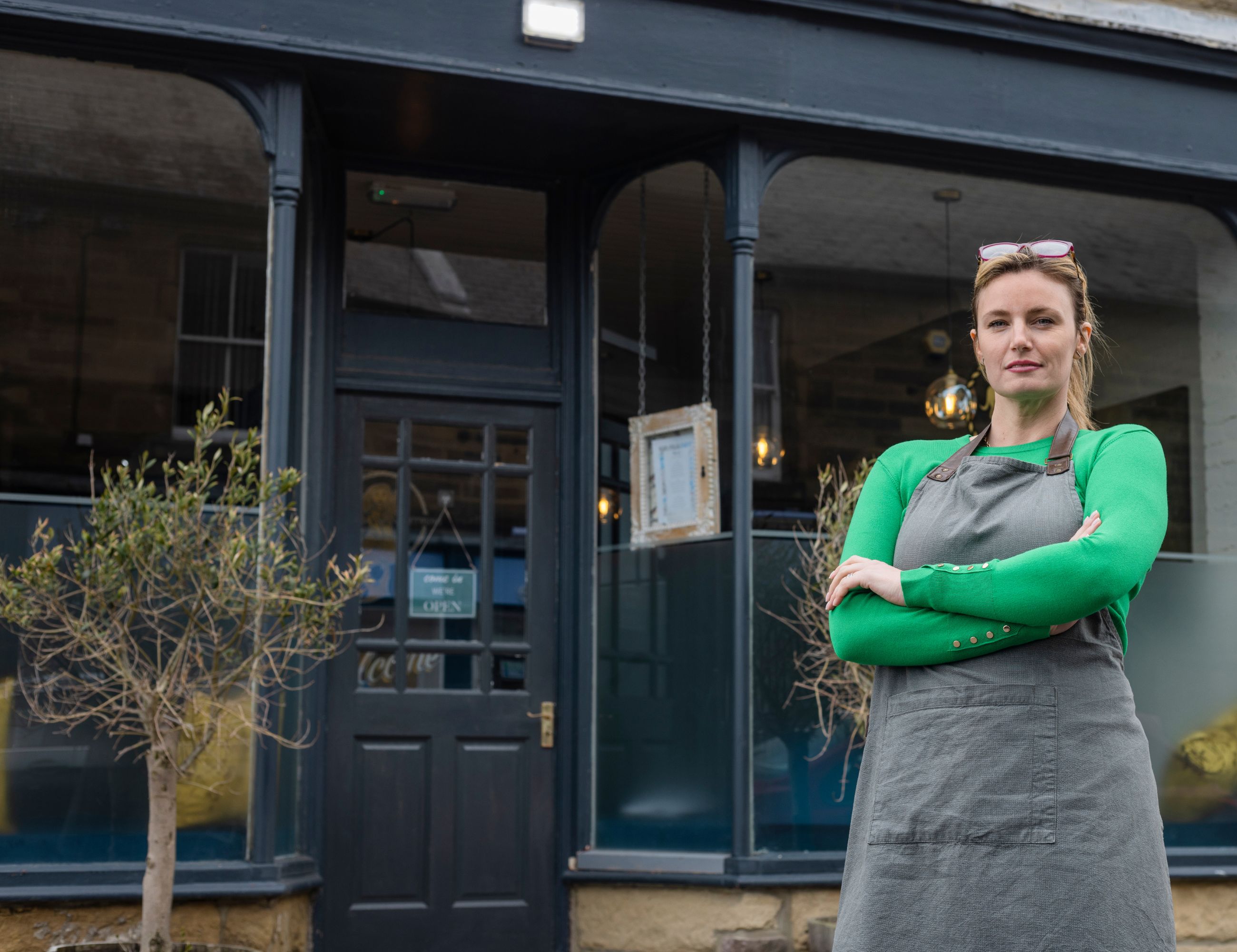 Image of a restaurant owner in front of a new restaurant