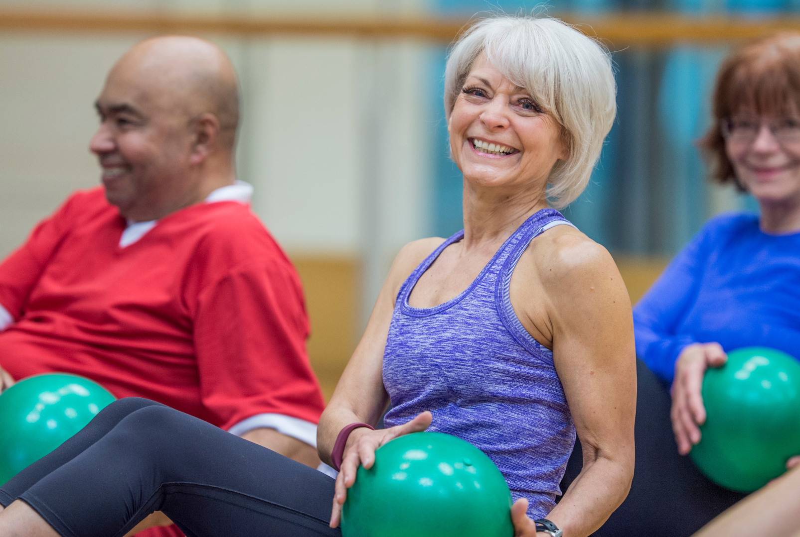 Three older adults participating in an exercise class